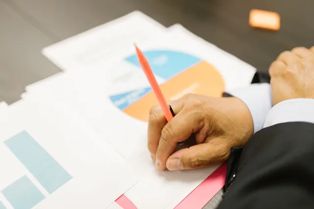 A businessman writing on financial documents with charts in an office setting. Operations case studies mistakes: the traps and the way around them