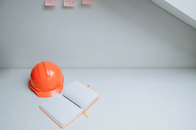 Minimalist workspace with orange hardhat and open notebook on a white desk, perfect for concept design. How OSHA recordkeeping rules shape process control documentation